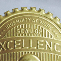 die cut, starburst, gold ink, embossed seal, excellence